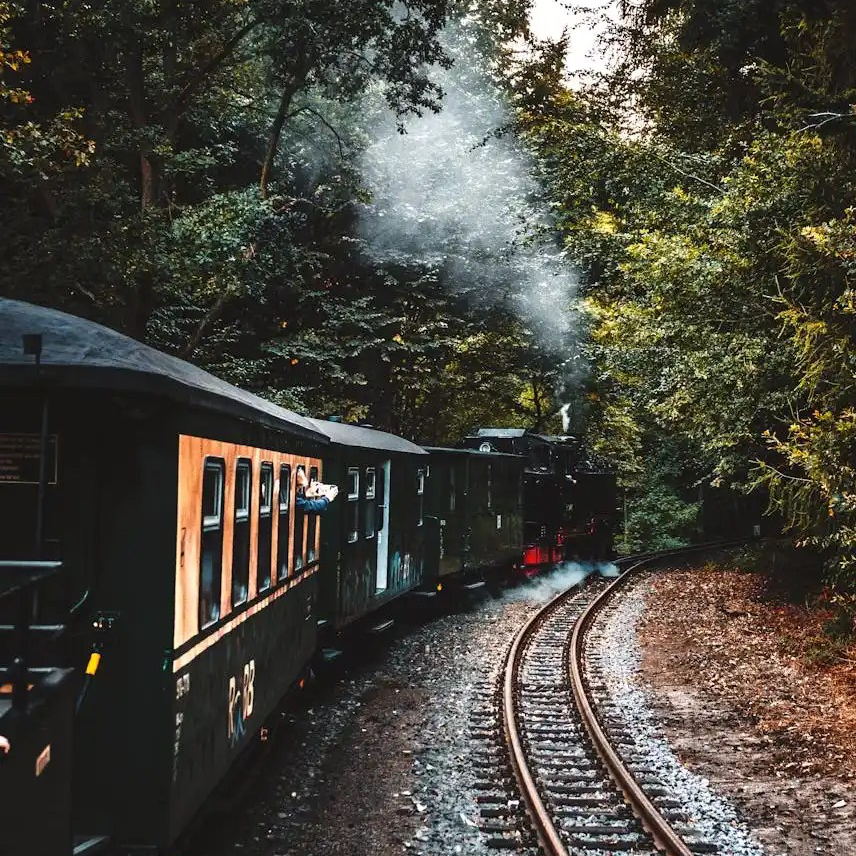 Een stoomtrein met wagons voor reizigers die per trein een lange afstand afleggen.